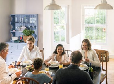 A group of people sitting at a table in front of a window